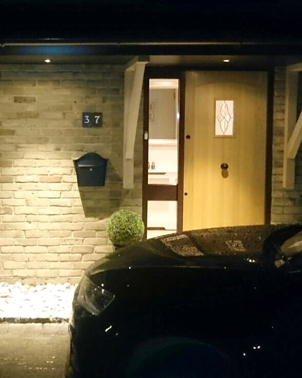 Covered porch and front entrance lit at night by ESL Electricians