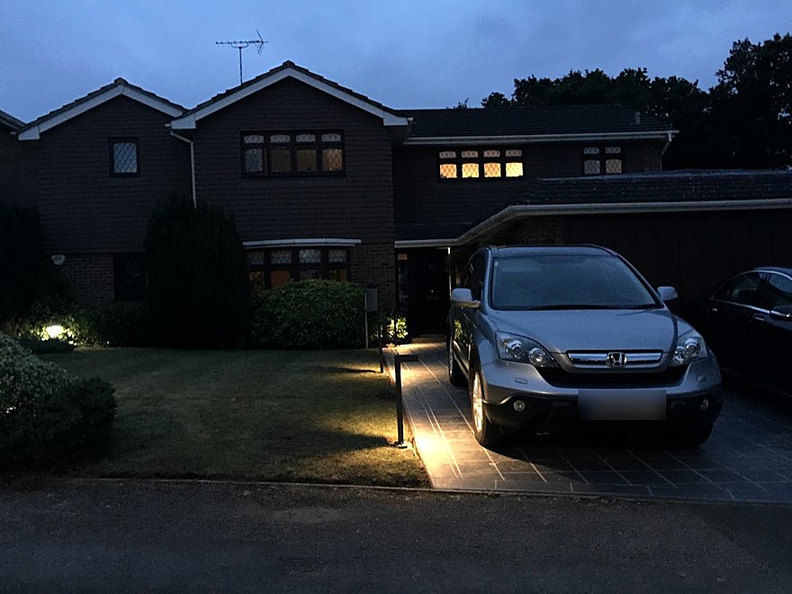 Driveway lit at dusk with bollard lighting along the approach