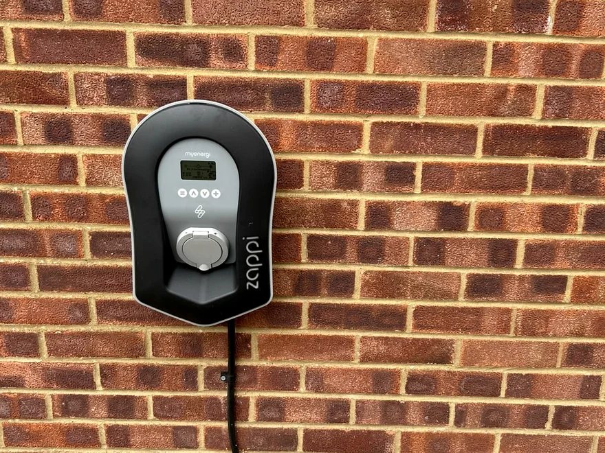 Home EV charge point installed on an external brick wall