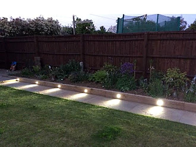 Recessed garden lights set into a raised border beside a lawn