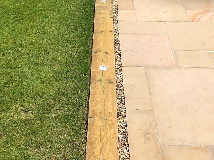 Recessed lights set into patio paving and timber edging