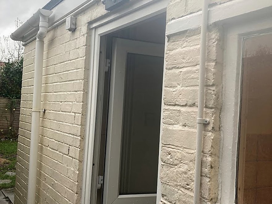 Security floodlight fitted above a doorway on a stone building