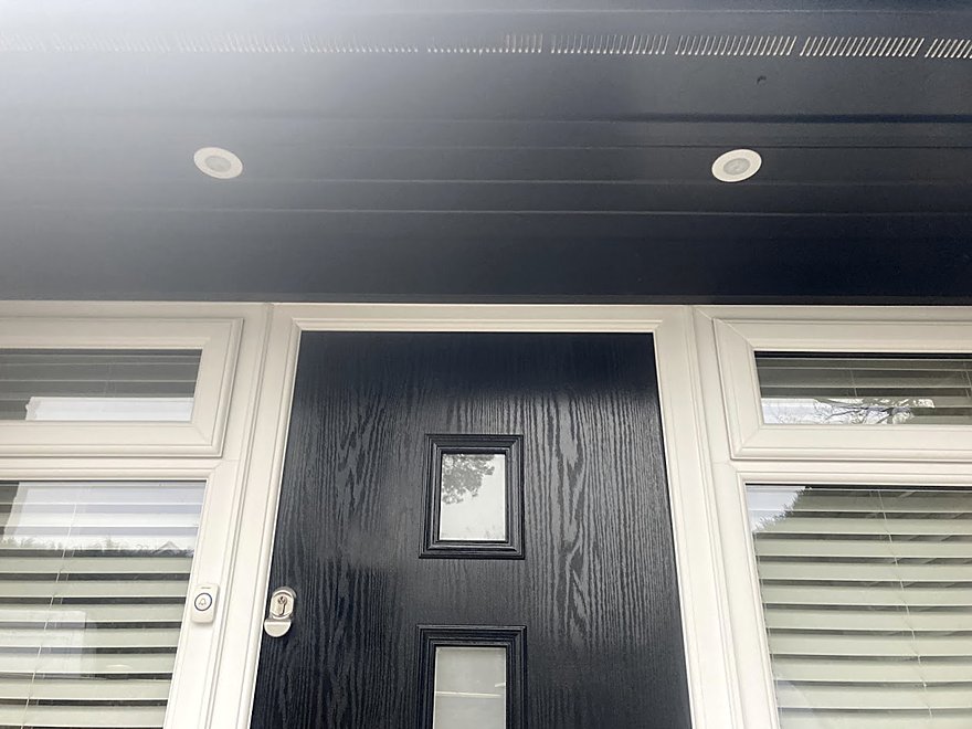 Downlights set into the soffit above a composite front door